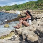 Assi sur un rocher face à la Porte d'enfer du Moule en Grande Terre en Guadeloupe